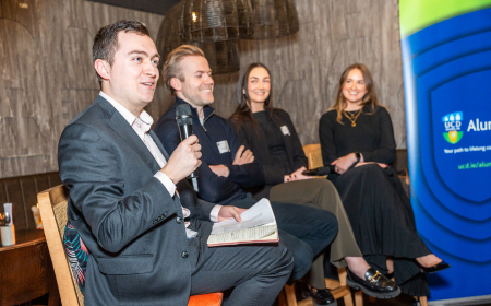Four UCD alumni speaking on a panel at a global event.